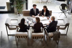 High angle view of financial advisors and customers discussing during meeting at law firm